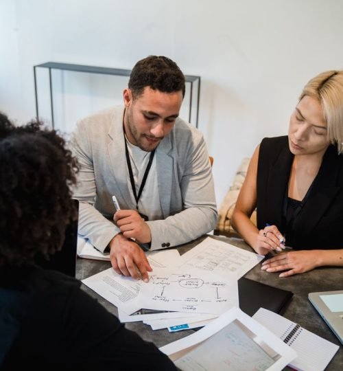 Diverse team engaged in collaboration, reviewing documents at an office desk.