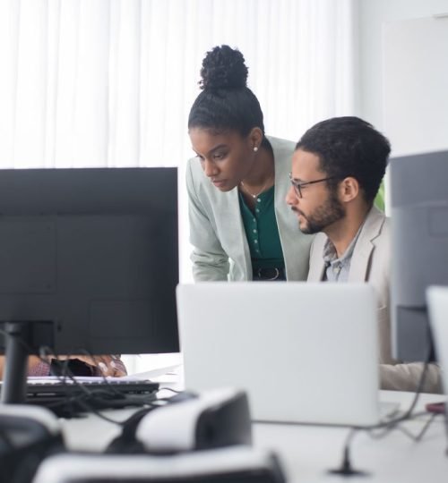 Two professionals collaborate in a modern office setting, promoting teamwork and innovation.